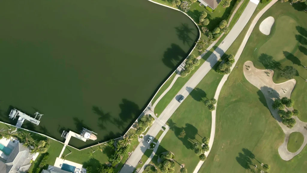 Aerial view of a lakefront golf community with manicured fairways in Vero Beach