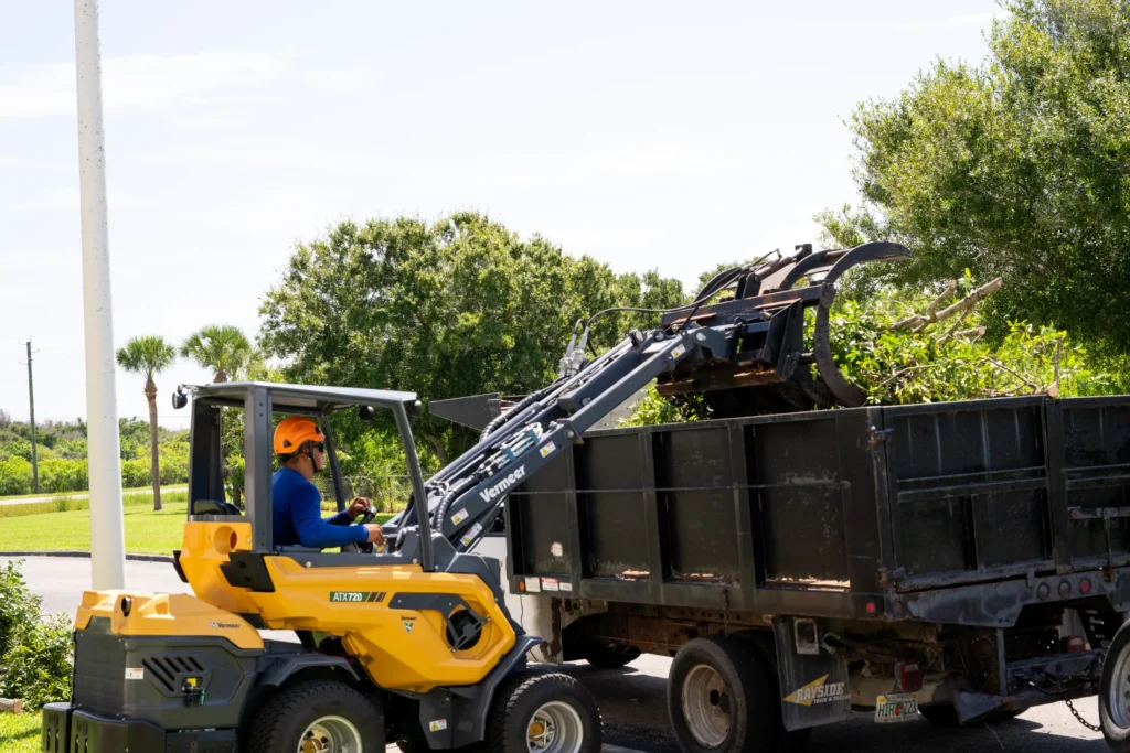 Loader filling a dump truck with debris